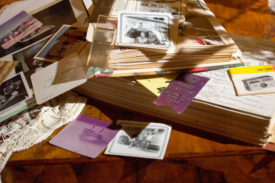 Various items of ephemera - photographs, notes, manuals et cetera laid out untidily on a table.