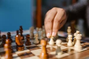 A close-up image of someone moving the pieces on a chess board.