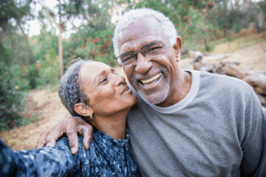 Two people, perhaps a husband and wife or brother and sister, laughing and kissing.