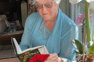 Private autobiography author Margot Griffiths holding her completed LifeBook, I Once Was a Rose.