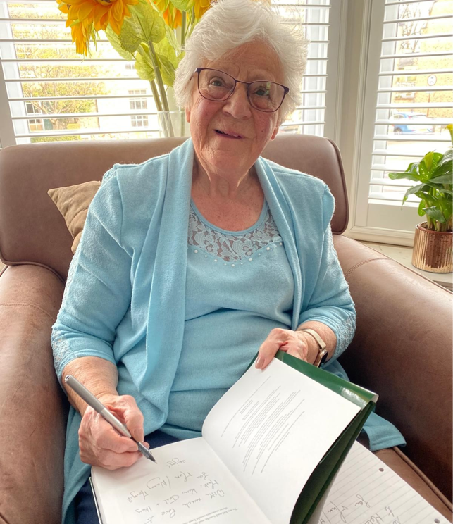 Private autobiography author Margot Griffiths signing her LifeBook at a family book-signing event.