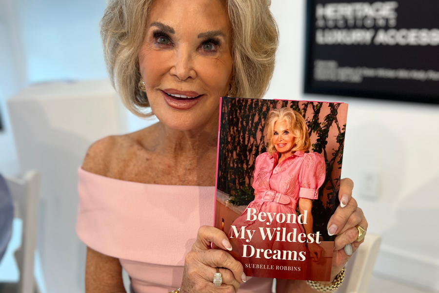 Palm Beach influencer and LifeBook author Suebelle Robbins, holding her private autobiography, Beyond My Wildest Dreams