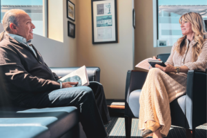 A photograph of a middle-aged lady interviewing an older man